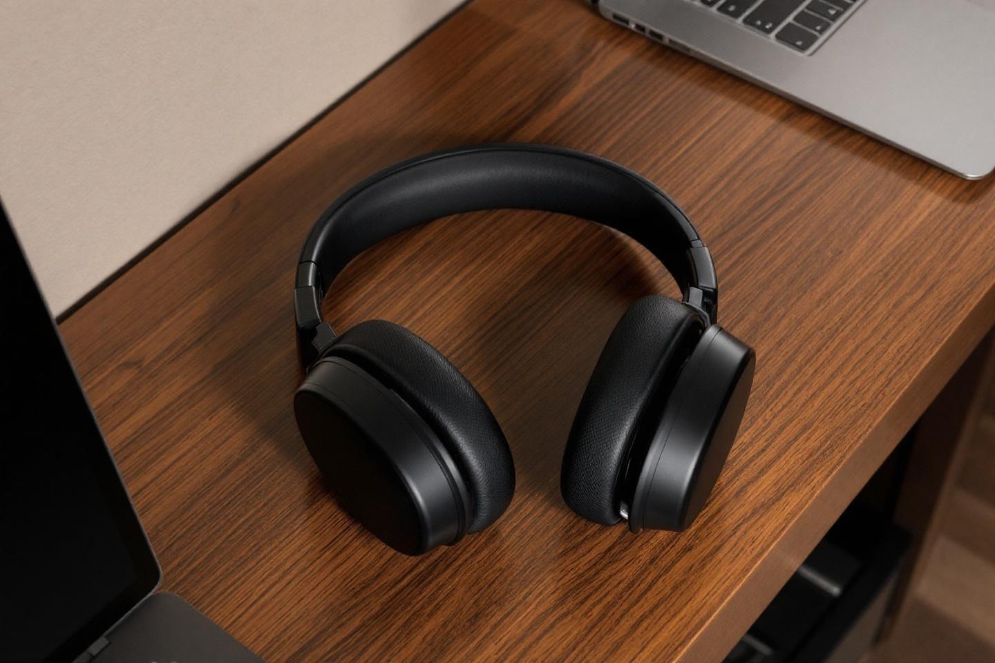 Casque sans fil noir posé sur une surface en bois