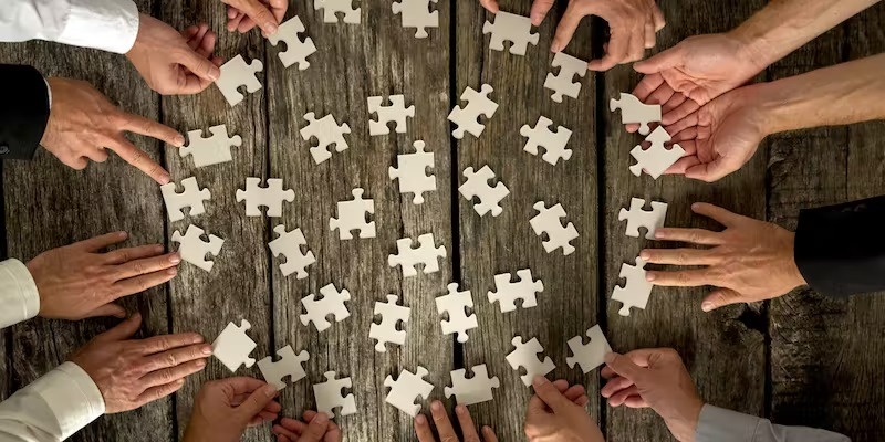 morceaux de puzzle entre les mains de plusieurs personnes