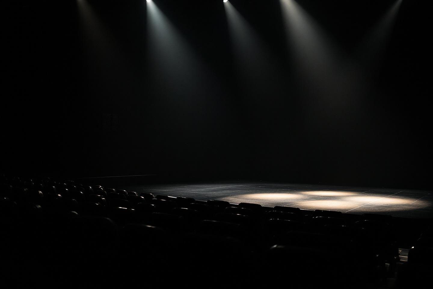 Scène de théâtre vide avec lumières dramatiques sur plateau