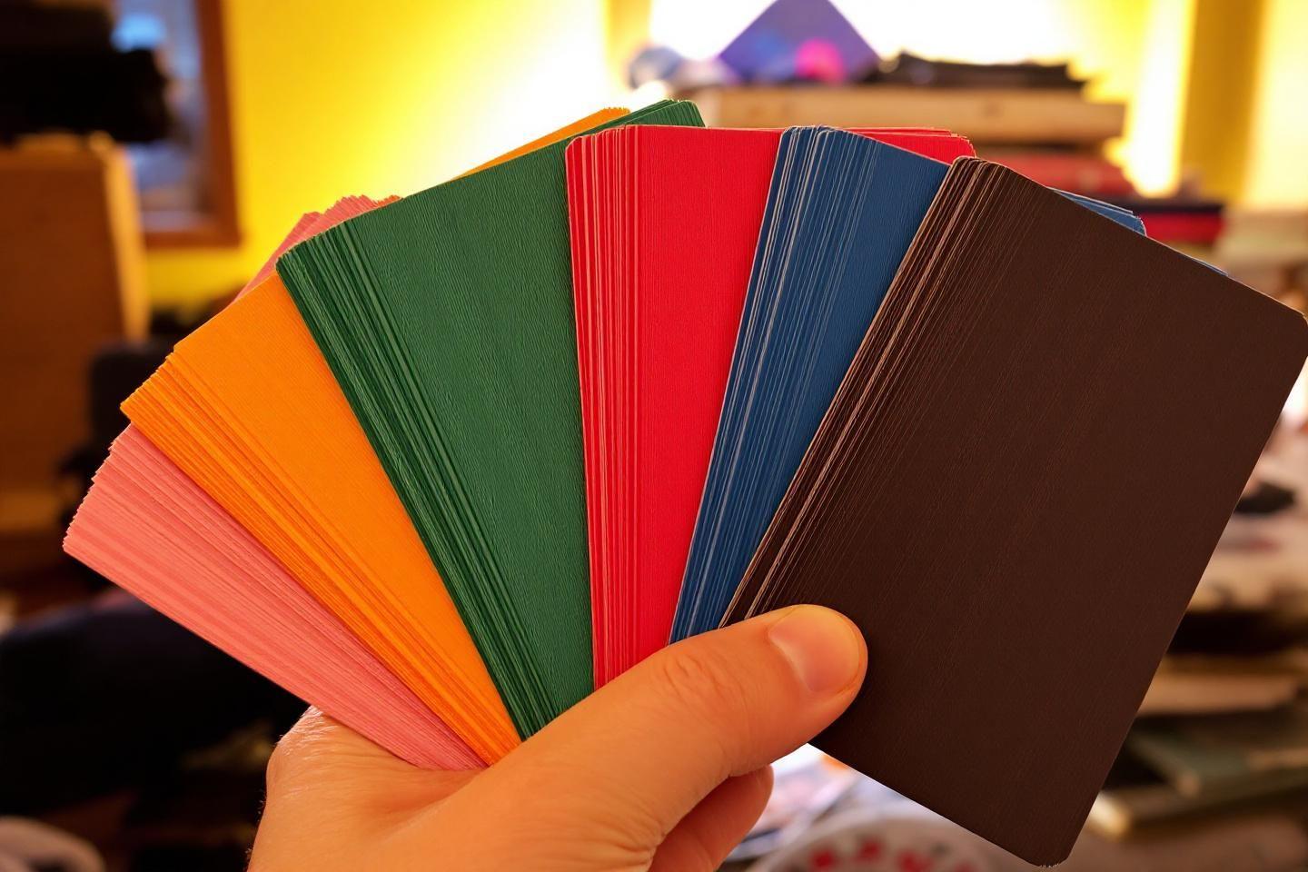 Main tenant un éventail de cartes aux couleurs variées