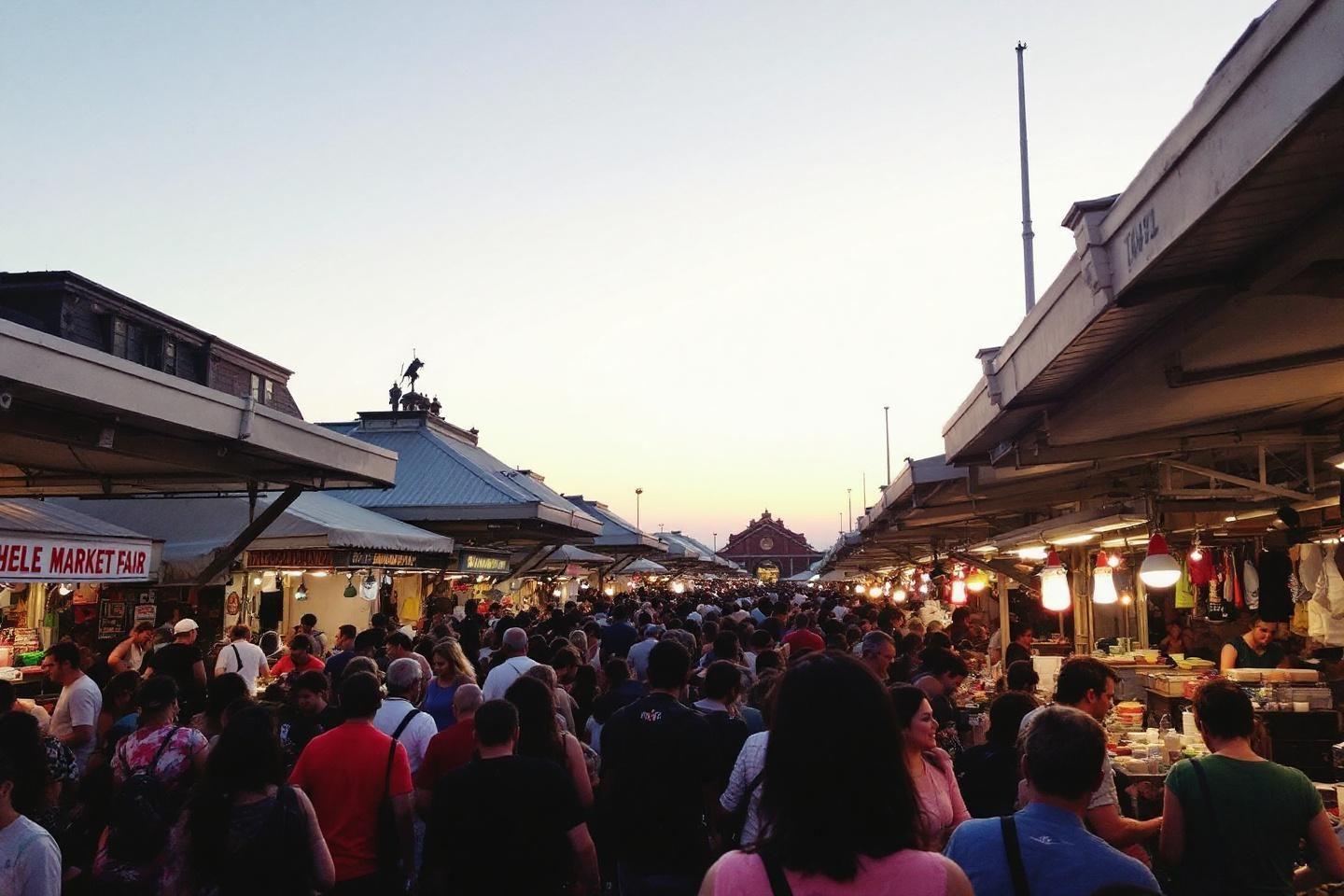 Foule dense dans un marché illuminé au crépuscule