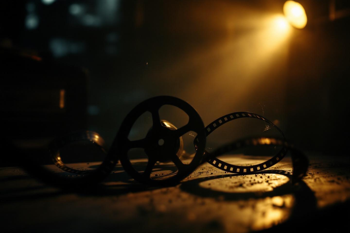 Bobine de film argentique illuminée par une lumière dorée
