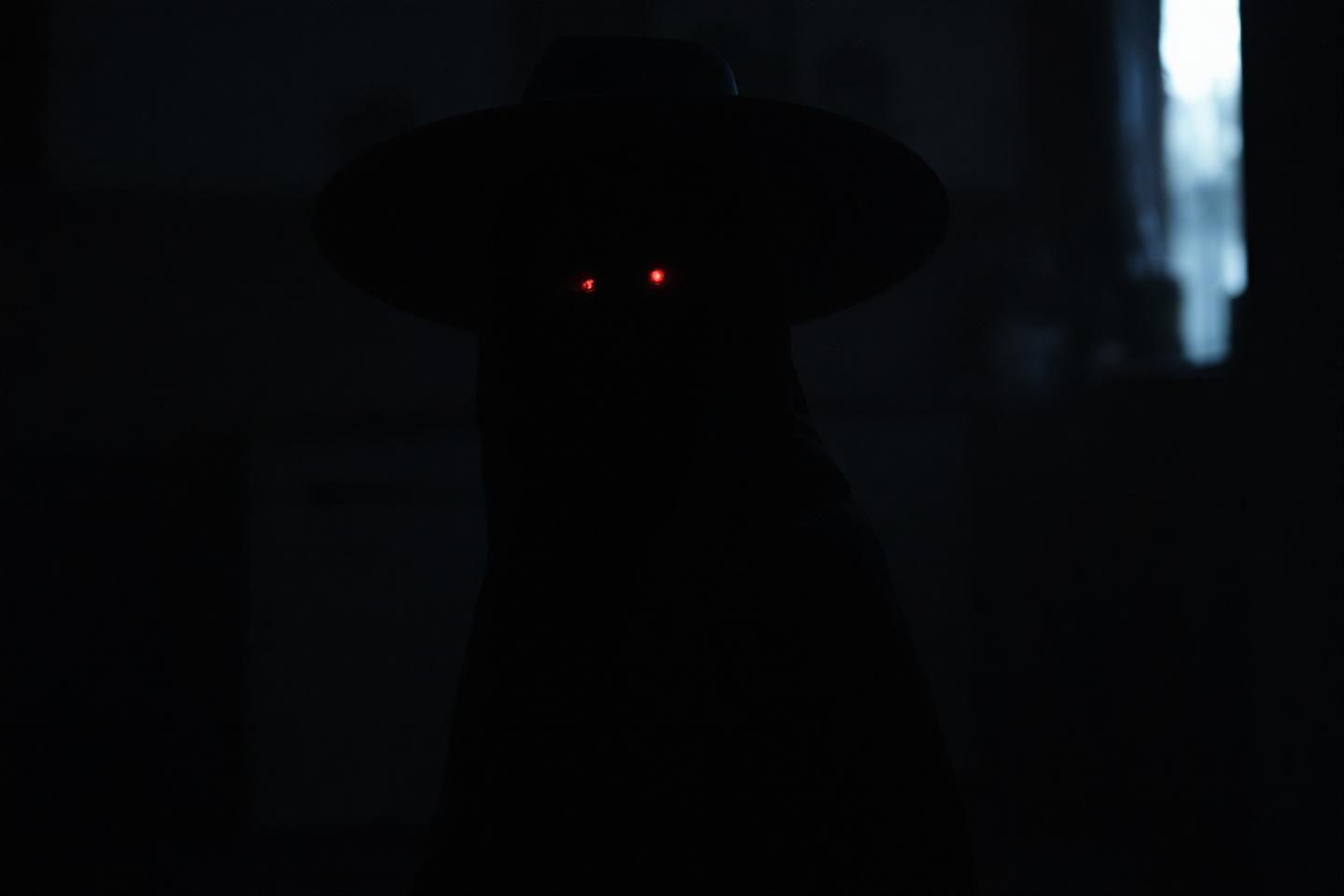 Silhouette sombre avec deux points lumineux rouges