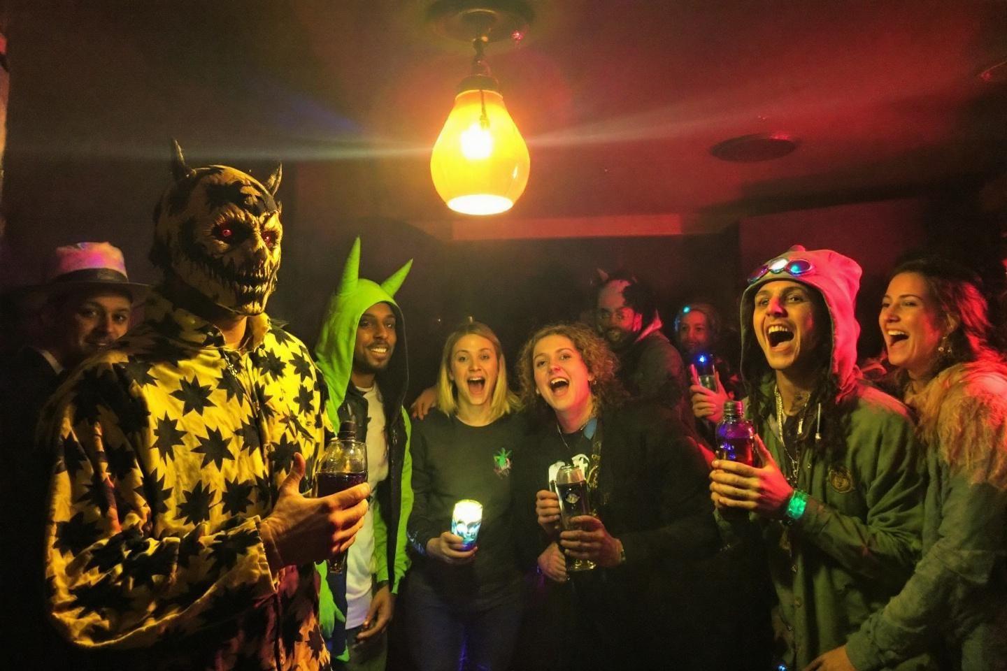 Groupe festif avec personnes d&eacute;guis&eacute;es riant sous lumi&egrave;re jaune