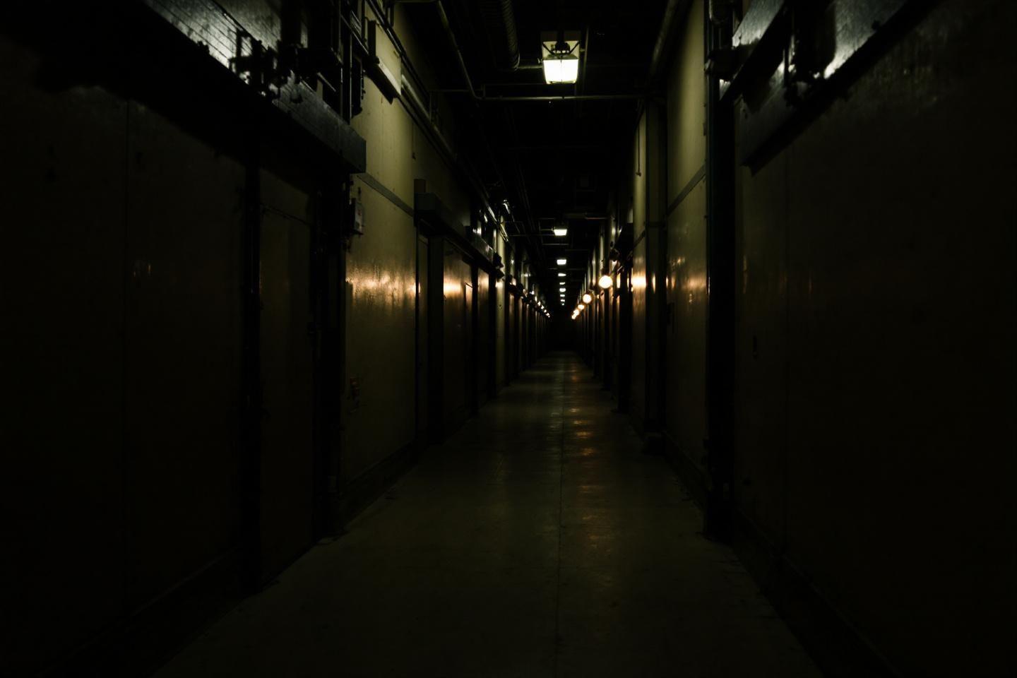 Corridor &eacute;troit et sombre avec des lumi&egrave;res le long des murs
