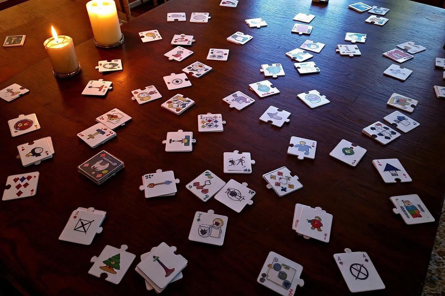 Cartes de jeu puzzles dispers&eacute;es sur une table en bois